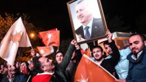 Supporters of Turkey's Justice and Development Party (AKP) hold up a portrait of Turkish President Recep Tayyip Erdogan as they celebrate in Istanbul after the first results in the country's general election on November 1, 2015. (AFP/Ozan Kose)