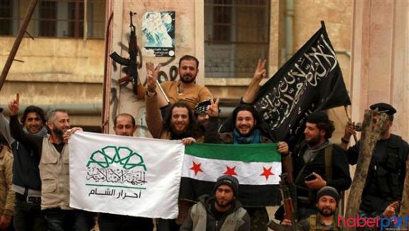 Army of Conquest fighters raise Ahrar-ash-Sham and Al-Nusra flags after taking the city of Idlib in March. Source: Haberport.