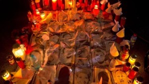 Candles are lit next to photographs of the victims outside the Colectiv nightclub in Bucharest Source: Associated Press